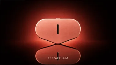 The device and its reflection, glowing against a red background.