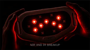 The LED side of the device lit red, held in two hands.